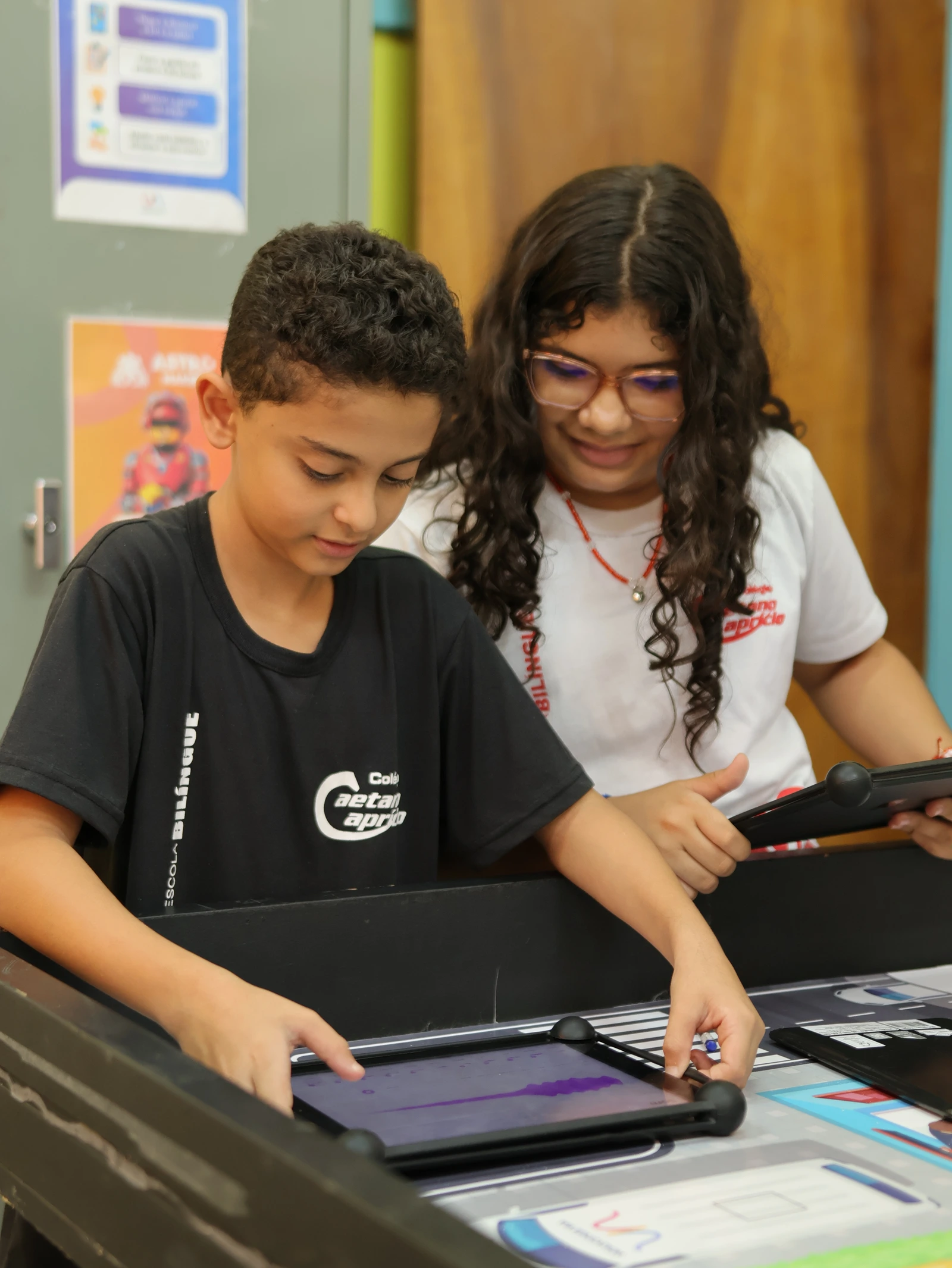 Dois alunos em atividade digital colaborativa, usando tablets